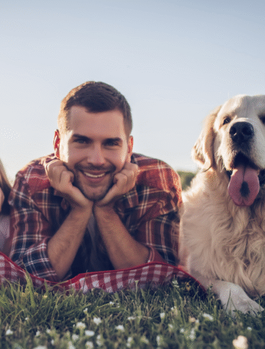Man relaxing outdoors with dog, representing companion animal wellness and healthy lifestyle.